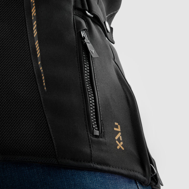 Detalj av Rebelhorn Jax MC-jacka med guldtryck och praktisk ficka med dragkedja. Perfekt för förvaring under körning.